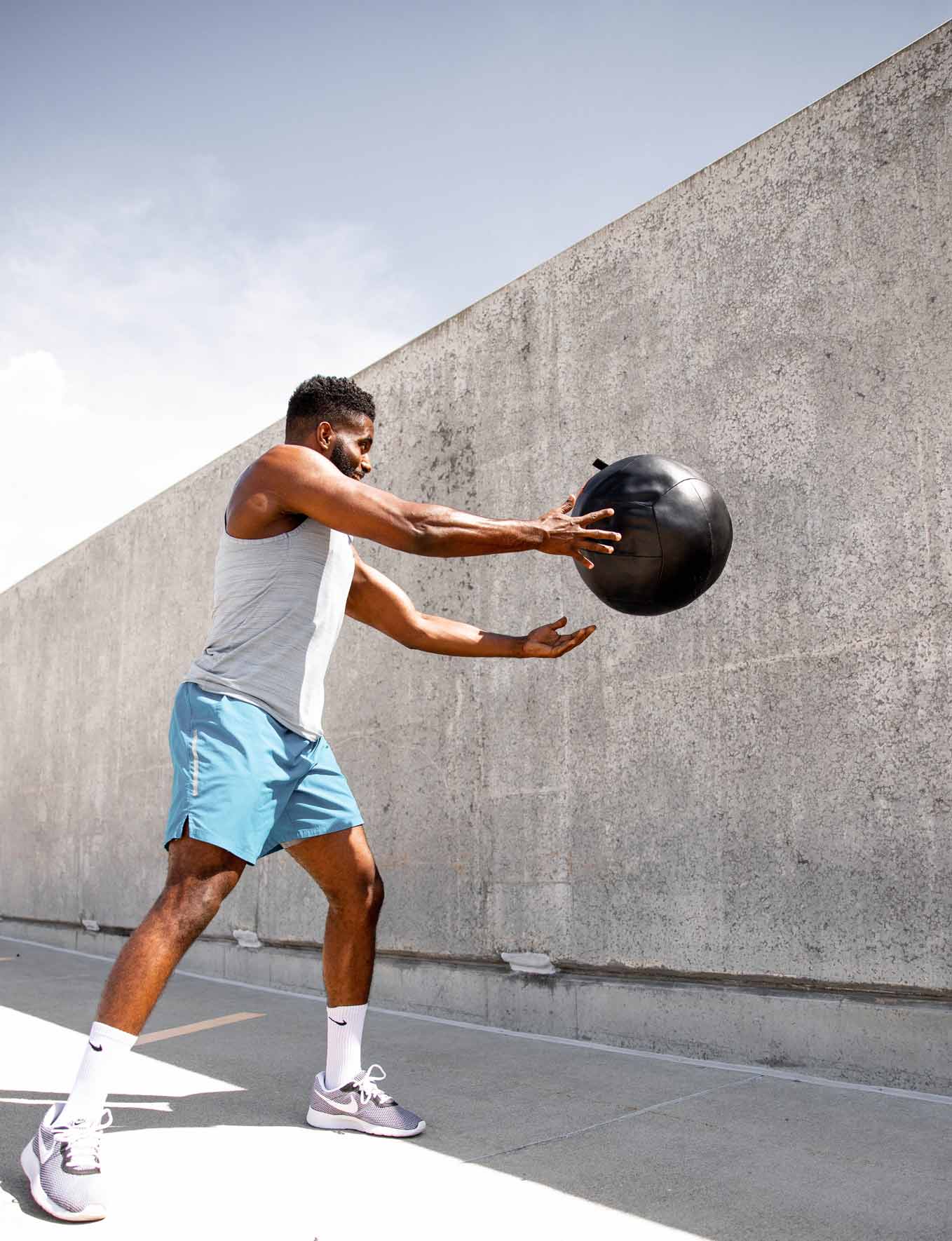 a person throws a ball at a concrete wall